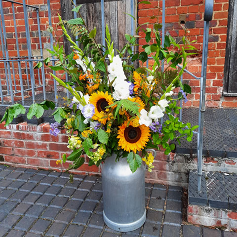 creative event flowers in milk churns